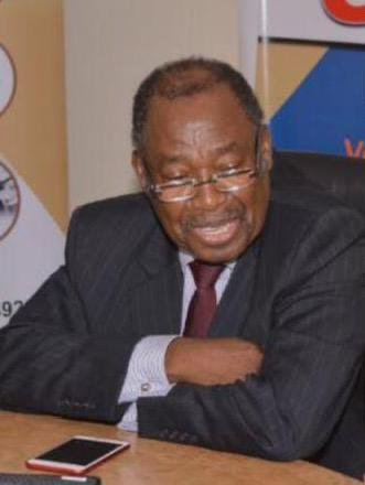 Dr Lanre Glover seated at a table during an indoor event
