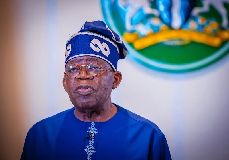 President Bola Tinubu wearing blue traditional attire and a matching cap