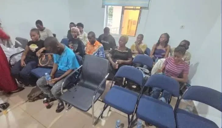 A group of released prospective corps members seated together inside a room
