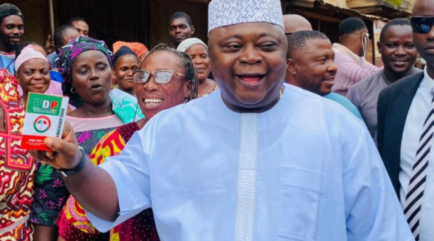 Oladipupo Adebutu standing among supporters while wearing traditional attire