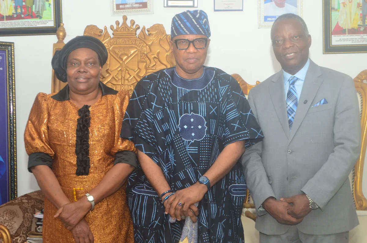 Glory Umoru, Oba Saheed Momson and Andrew Umoru standing together during a visit in Agbowa-Ikosi