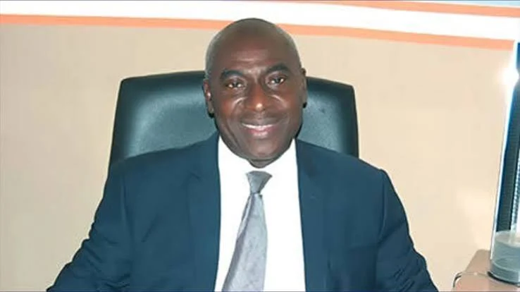 Lanre Arogundade seated in an office wearing a dark suit and tie