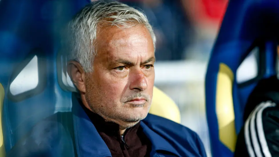 José Mourinho seated during a football match