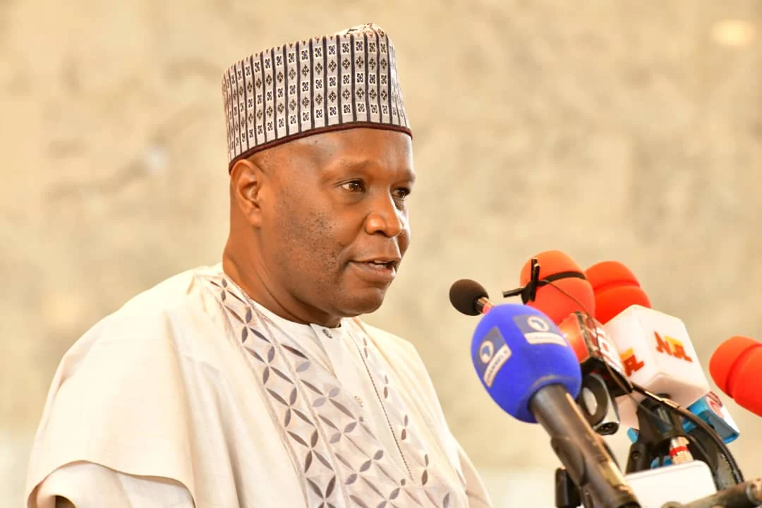 Gombe State Governor Inuwa Yahaya speaking at a cluster of microphones